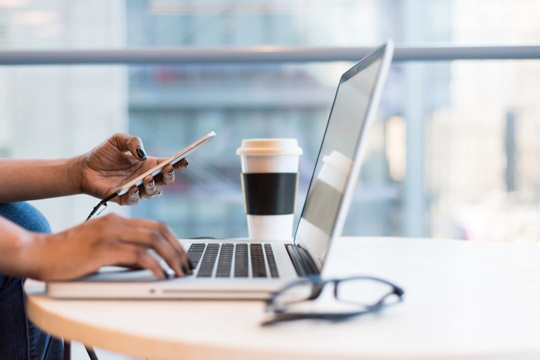 Close up of hands typing on a laptop with business charts
